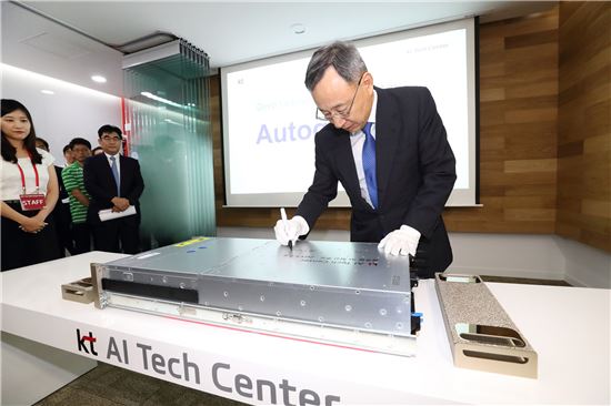KT 황창규 회장이 우면동 KT 융합기술원에서 열린 'AI 테크센터' 개소식에서 기념 서명을 하고 있다.