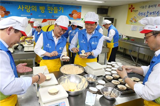 26일 서울 종로구 희망나눔 봉사센터에서 신한은행 임원 및 본부장들이 인근 독거노인에게 전달될 빵을 직접 만들고 있다. (사진 : 신한은행)