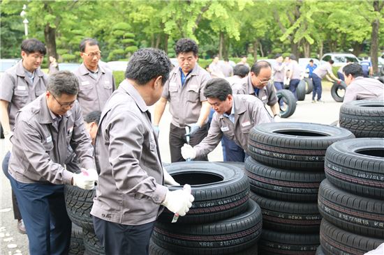 지난 28일 광주 금호타이어 공장에서 이한섭 사장과 임직원들이 '타이어 절단식'을 실시하고 있다.
 


