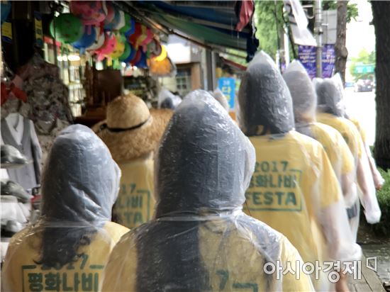 일본군 위안부 문제 해결을 위해 활동하는 평화나비네트워크 소속 대학생들이 31일 우비를 입은 채 행진하고 있다. 이날 오후 서울 중구에는 비가 내렸다. (사진= 정준영 기자)