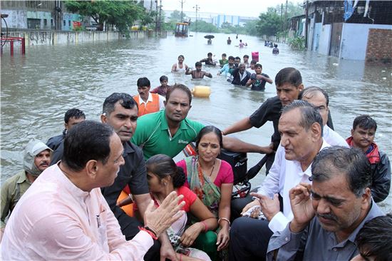 홍수로 인해 대부분의 집이 잠긴 인도 서부 구자라트주에서 주민들이 보트를 타고 대피하고 있다. (사진출처=EPA연합)