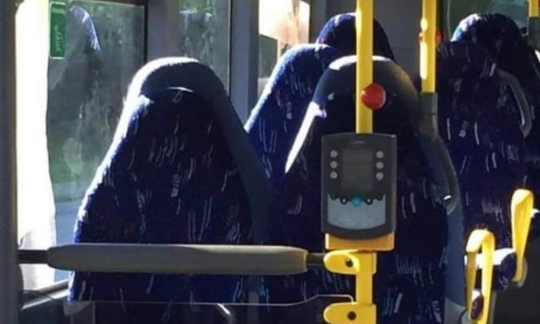 부르카 입은 여성이 앉아 있는 것처럼 보이는 텅 빈 버스 사진. 사진=영국 가디언