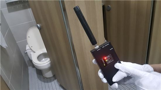 서울시 여성안심보안관이 전자파 탐지기를 손가락으로 가리키고 있다. 전자파 탐지기는 몰카의 전자파를 감지하면 경고음을 낸다.