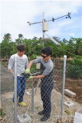▲바이니 지역에서 신용희(왼쪽), 김광형 박사가 강수량 측정장치를 교체하고 있다.