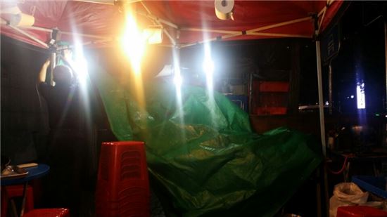 11일 밤 여의도의 한 포장마차에서 소나기를 피하기 위해 천막을 치고있다. 