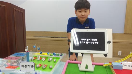 ▲안덕룡 경북 녹전초등학교의 5학년생이 자신이 만든 '구슬게임' 앞에서 포즈를 취하고 있다. 