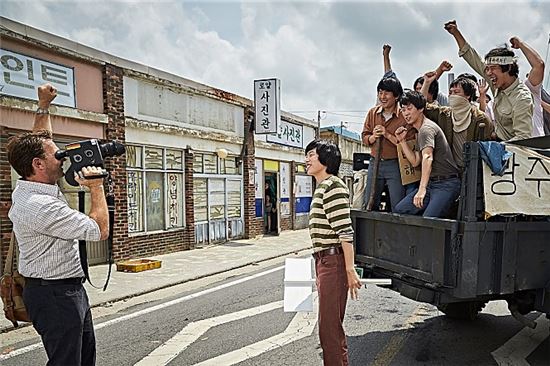 '택시운전사'에서 독일 기자 위르겐 힌츠페터가 '훌라송'을 부르는 광주 학생들을 촬영하고 있다. (사진=영화 택시운전사 스틸 이미지)
