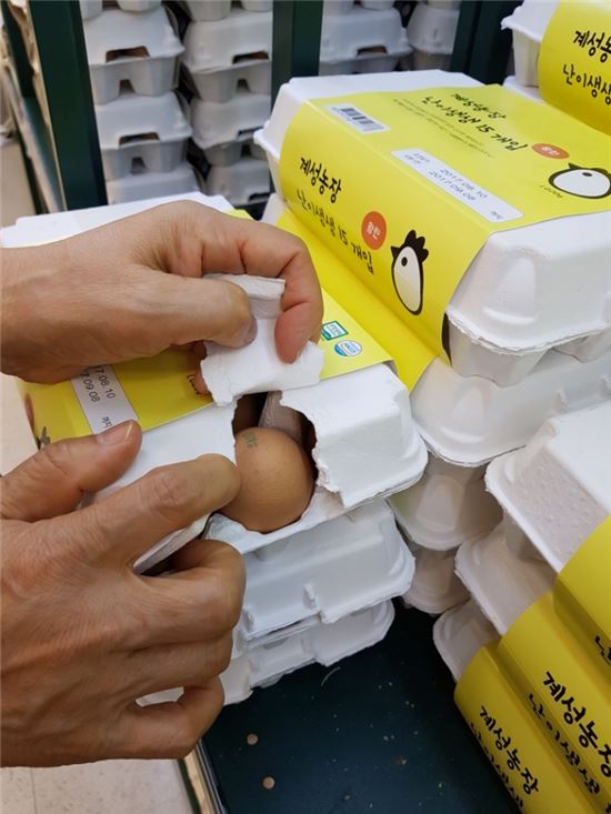 17일 서울시내 한 대형마트에서 계란의 난각코드를 확인하기 위해 한 주부가 포장지를 찢고있다 