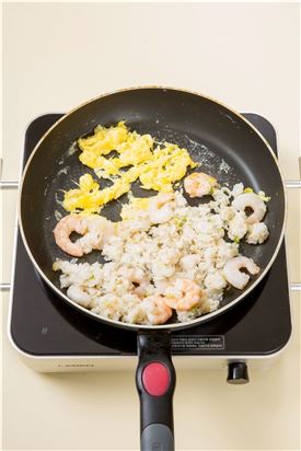 4. 새우가 어느 정도 익으면 팬의 한켠에 달걀을 깨어 넣고 스크램블 하여 섞은 다음 소금과 후춧가루로 간한다.