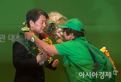 [포토]꽃목걸이 받는 안철수 신임 당 대표