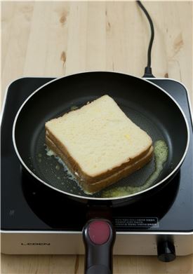 5. 팬을 달구어 버터를 적당량 두르고 식빵을 넣어 앞뒤를 노릇하게 구운 후 크림치즈가 말랑해지도록 은근한 불로 굽는다. 