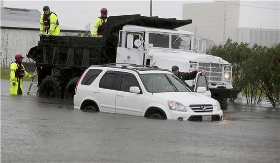 허리케인 하비가 덮친 미국 텍사주에서 29일(현지시간) 물에 잠긴 자동차를 구조대원들이 견인하고 있다.(사진출처=AP연합)