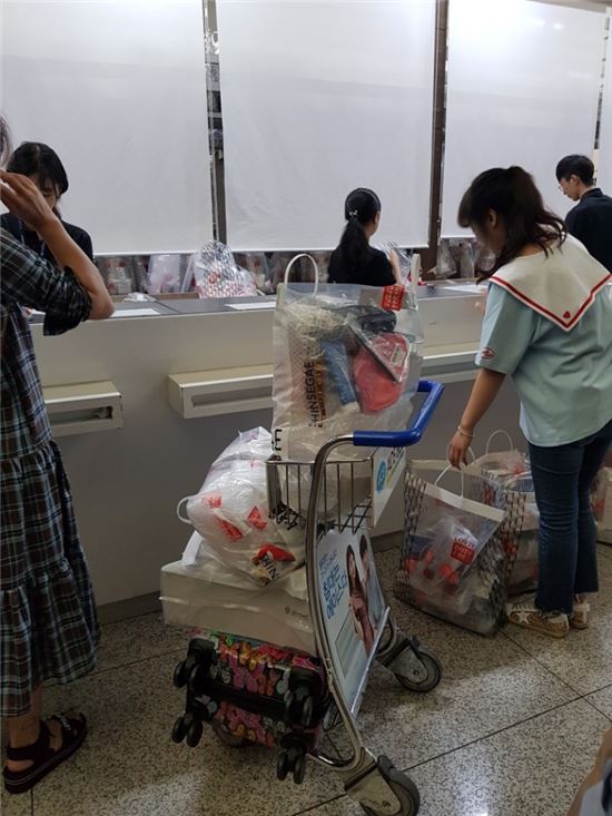 지난달 27일 인천국제공항 출국장 면세점 인도장에서 면세품을 무더기로 찾는 모습. 