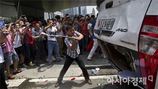 중국에서 발생한 한 반일(反日)집회에서 한 시민이 일본산 자동차를 부수고 있다.<자료사진>