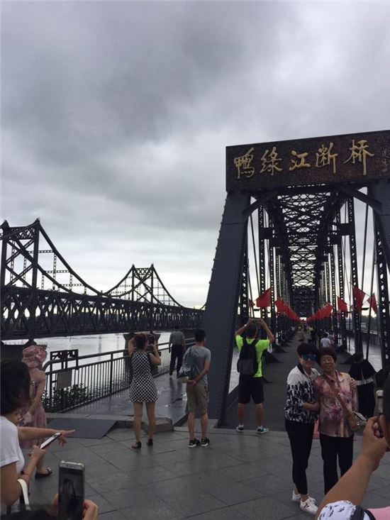압록강단교를 찾은 중국인 관광객들이 기념사진을 찍고 있다. 왼편에는 중국 단둥시와 북한 평안북도 신의주를 잇는 중조우의교가 자리하고 있다. [단둥=김혜원 특파원]