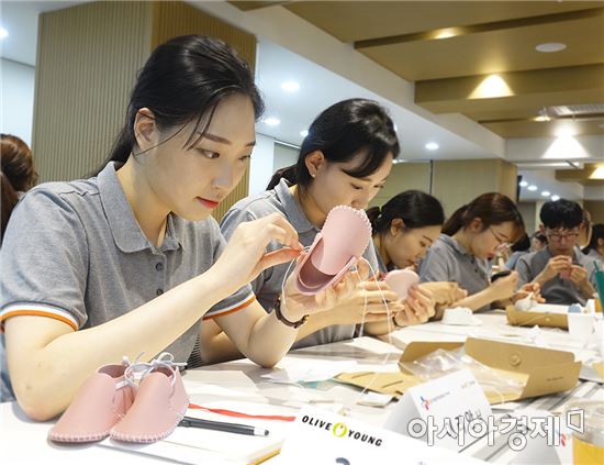 올리브영 신입사원들이 입양을 기다리는 아기들을 위해 걸음마 신발을 만들고 있다. 
