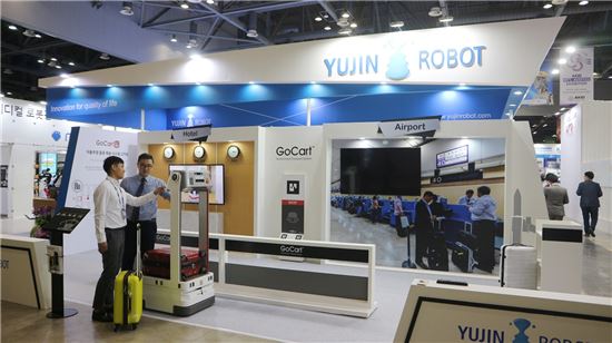 공항과 호텔을 재현한 유진로봇의 부스에서 자율주행 물류배송 로봇 '고카트'가 캐리어 운반 서비스를 시연하고 있다.