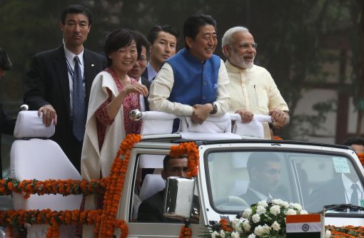 [이미지출처=EPA연합뉴스] 인도 전통 의상을 입은 아베 신조 일본 총리가 13일 나렌드라 모디 인도 총리와 함께 꽃으로 단장된 무개차를 타고 이동하고 있다. 