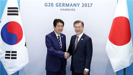 문재인 대통령이 지난 7월8일 독일 함부르크에서 열린 주요 20개국 정상회의(G20)에서 아베 신조 일본 총리와 악수하고 있다.[사진=청와대]