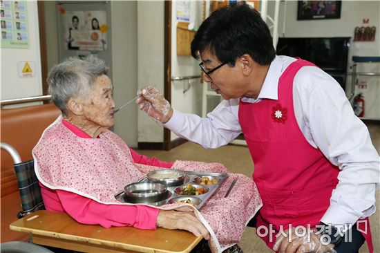 김성 장흥군수가 노인요양벙원에서 한 어르신에게 식사배식 봉사를 하고있다. 