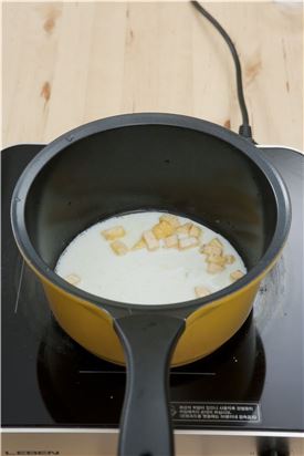 4. 냄비에 버터를 두르고 고구마를 넣어 볶다가 우유 1+1/2컵과 설탕, 계핏가루를 넣어 주걱으로 저어가며 졸인다.