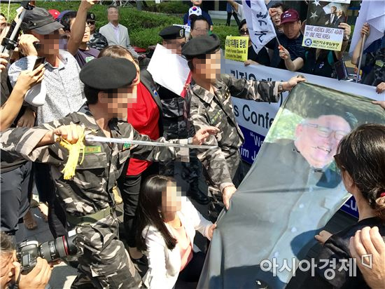 지난 22일 서울 종로구 광화문 인근에서 한 보수단체가 김정은 북한 노동당 위원장의 사진을 참수하는 퍼포먼스를 벌이고 있다. (사진=정준영 기자)