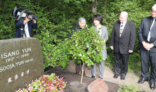 문재인 대통령 부인 김정숙 여사가 독일 베를린 가토우 공원묘지에 있는 윤이상 묘소를 찾아 식재된 동백나무를 보고 있다. [이미지출처=연합뉴스]