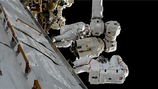 ▲두 명의 우주비행사가 우주유영을 통해 로봇팔에 새로운 장비를 장착하고 있다.[사진제공=NASA]