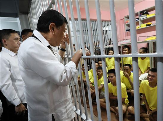 [사진=EPA연합] 로드리고 두테르테 필리핀 대통령이 창살을 사이로 수감자들과 대화하고 있다.