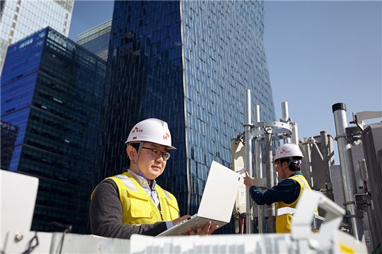SK텔레콤 5G연구원들이 서울 명동의 건물 옥상에 설치된 5G 기지국에서 LTE-5G 장비·주파수 연동 결과를 측정하고 있다.