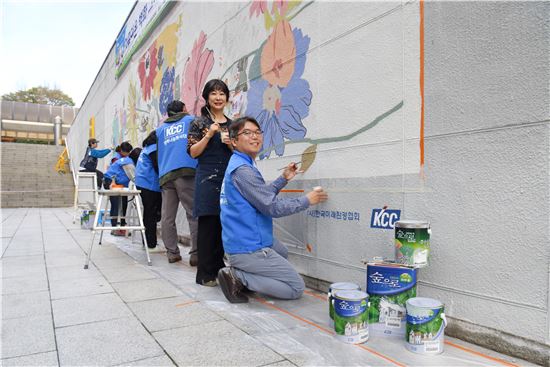 맨 앞쪽부터 홍일화 화가와 'KCC 행복나눔' 임직원, 한국미래환경협회 임직원 등이 대형 벽면에 그림을 그리는 아트 컬레버레이션 활동을 하고 있다. 