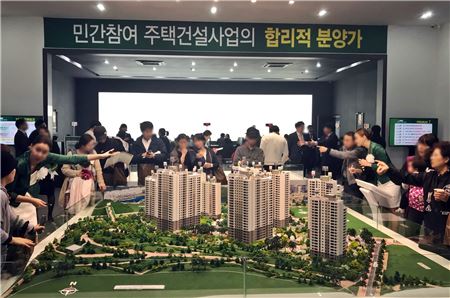 지난 27일 문을 연 경기 화성시 '동탄 레이크 자연& 푸르지오' 견본주택을 찾은 관람객들이 단지모형을 보고 있다.