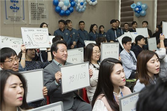 이웅열 코오롱그룹 회장(사진 가운데)이 지난 4월 '인보사' 생산라인이 있는 코오롱생명과학 충주공장을 찾아 인보사의 의미를 적는 이벤트에 참여해 '981103' 숫자를 쓴 칠판을 들어보이고 있다.