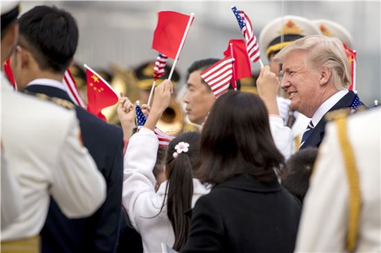 어린 아이들이 8일(현지시간) 중국 베이징공항에 도착한 도널드 트럼프 미국 대통령 부부를 향해 양국 국기를 흔들면서 환영하고 있다. [사진=AP연합]