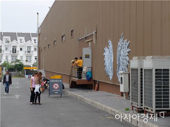 젊은 베트남 여성 2명이 이마트 고밥점 외부 벽면에 그려진 날개 앞에서 사진을 찍으려 하고 있다.(사진=오종탁 기자) 