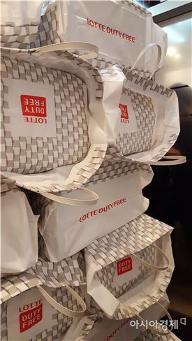 롯데면세점 본점에서 한 중국인 보따리상이 화장품이 든 비닐 가방을 키 높이 이상으로 쌓아 엘리베이터에 탄 모습.(아시아경제 DB)