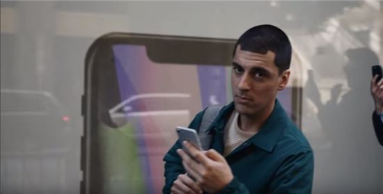 삼성전자가 제작한 애플 디스 광고 중 한 장면. 특이한 헤어스타일을 한 출연자의 바로 뒤 배경에 노치가 두드러진 아이폰X이 보인다. 헤어스타일을 통해 아이폰X의 상단부 'M'자형 노치 디자인을 조롱하고 있다.