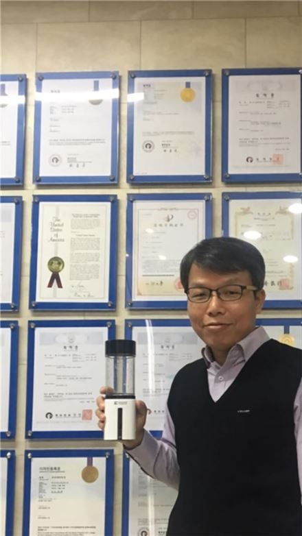 김성태 파이노 대표가 수소수 생성기의 핵심 기술과 관련한 국내외 특허증들 앞에서 포즈를 취하고 있다. 