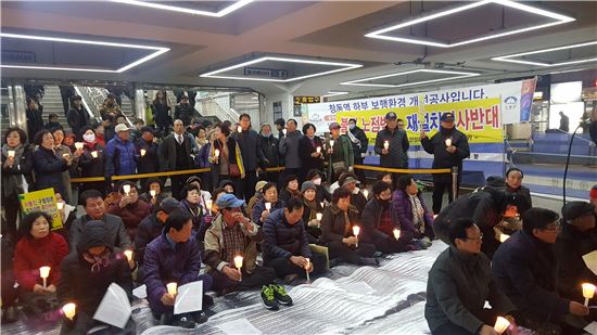 지난 13일 오후 7시 도봉구 창동역 2번출구 앞에서 주민 50여명이 '노점상 재설치 결사반대' 촛불집회를 벌이고 있다.