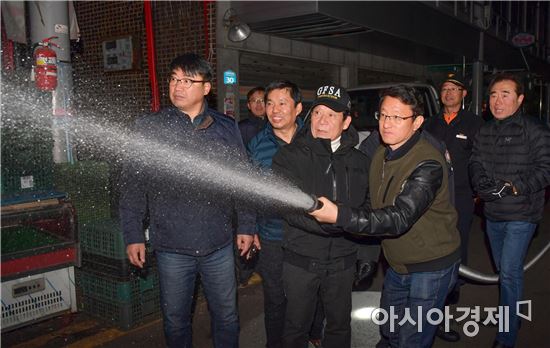 윤장현 광주광역시장이 영하권 날씨를 보인 18일 저녁 양동시장과 말바우시장을 차례로 돌면서 동절기 화재예방 및 시설물 안전점검을 실시했다. 이날 북구 말바우시장을 찾은 윤장현 시장이 관내 소방대원 및 상인대표와 함께 시장 내 설치된 비상소화전으로 물을 뿌려보고 있다./광주광역시 제공
