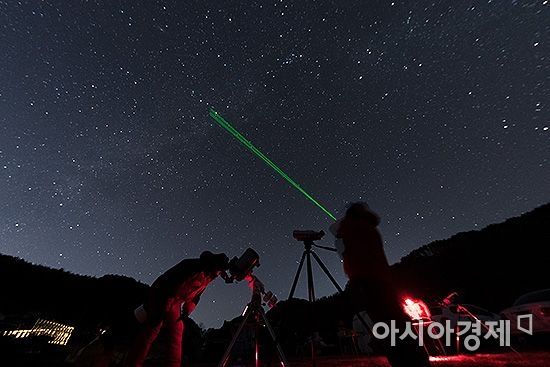 변성식 씨(오른쪽)가 레이저빔을 이용해 가을 은하수를 기자에게 가르치고 있다./강원도 횡성=윤동주 기자 doso7@