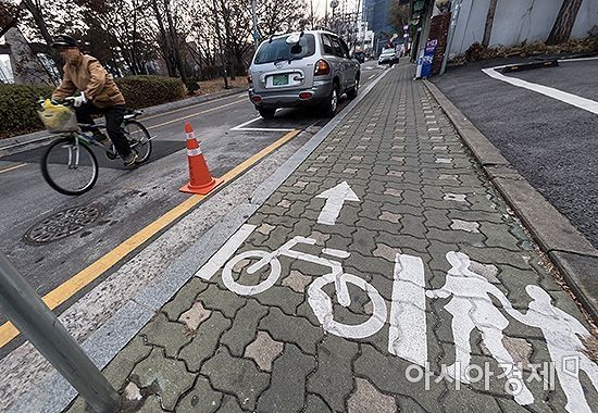 자전거?보행자겸용도로 옆 일반도로로 자전거운전자가 역주행을 하고 있다./윤동주 기자 doso7@
