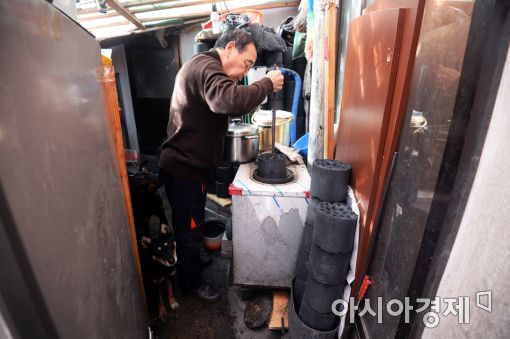 서울 노원구 상계3·4동의 한 주민이 부엌에서 밥을 짓기 위해 연탄불을 피우고 있다. 