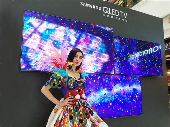 삼성전자 모델이 중국 상하이 타임스퀘어에서 열린 'QLED 카니발' 행사장에서 삼성 QLED TV 제품을 소개하고 있다.