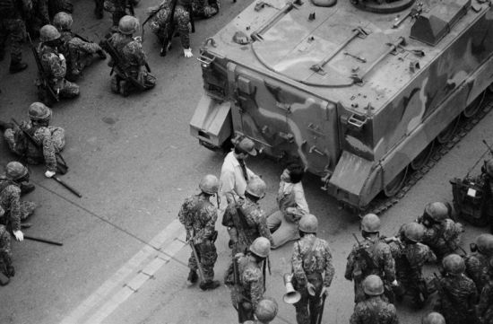 1980년 5월18일 광주 금남로에서 시민과 학생들이 군사정권 퇴진을 요구하며 대형 버스를 앞세우고 시위하는 학생을 계엄군이 연행해 탱크 앞에서 무릎을 꿇리고 있다. 사진=연합뉴스