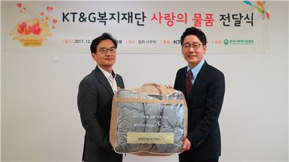 김지형 KT&G복지재단 사무국장(좌)이 신용규 한국사회복지관협회 사무총장(우)에게 이불을 전달하고 있다. 
