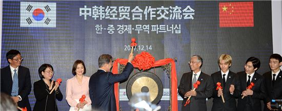 문재인 대통령이 KOTRA가 14일 중국에서 연 ‘한-중 경제무역 파트너십’ 행사에 참석해 개막을 알리는 징을 치고 있다.