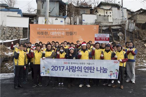 ▲OCI 김재신 사장(맨 앞줄 오른쪽에서 네번째)과 임직원들이 14일 서울시 중계동 백사마을에
1만장의 연탄나눔과 배달봉사를 한 후 기념촬영을 하고 있다.