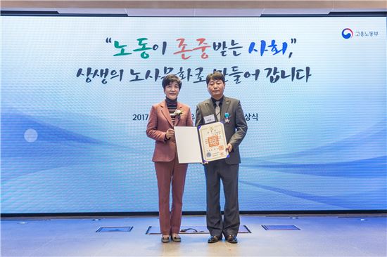 이동용 SK인천석유화학 노조위원장(오른쪽)이 ‘산업포장’을 수상한 후 김영주 고용노동부 장관과 함께 사진 촬영을 하고 있다.