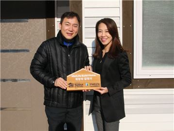 지난 16일 강원도 홍천에서 진행된 '메트라이프 희망의 집 헌정식'에서 황애경 메트라이프코리아재단 사무국장(오른쪽)과 이종태 한국해비타트 사업관리본부장이 헌정 문패를 들고 기념촬영을 하고 있다.(사진=메트라이프생명)